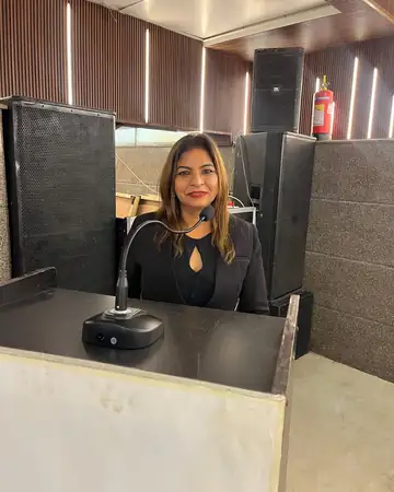 Anu Manocha smiling at the lectern at a conference