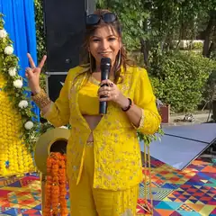 Anu Manocha smiling with mic at a haldi ceremony