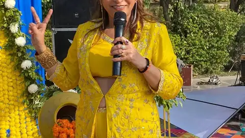 Anu Manocha smiling with mic at a haldi ceremony