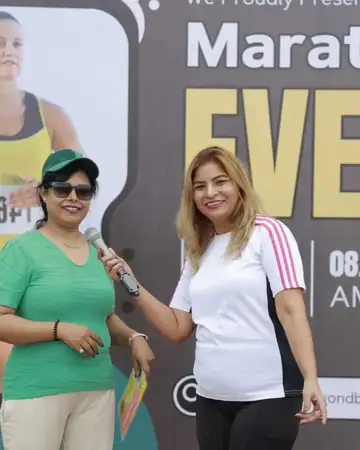 Anu Manocha with a guest on stage at a marathon event