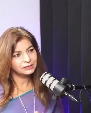 Anu Manocha speaking into a studio microphone during a podcast