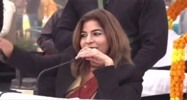 Anu Manocha smiling at the mic during a spiritual gathering