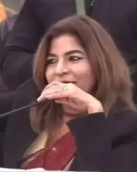 Anu Manocha smiling at the mic during a spiritual gathering