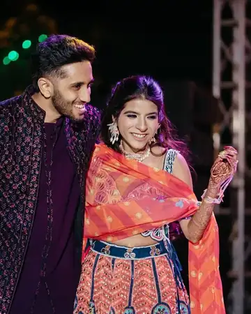 Anu Manocha with the couple on stage at an outdoor sangeet night