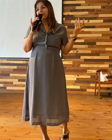 Anu Manocha hosting a seminar session on a wooden stage