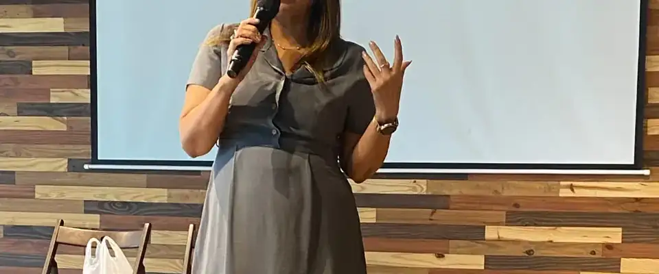 Anu Manocha hosting a seminar in front of a projector screen