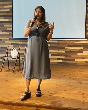 Anu Manocha hosting a seminar in front of a projector screen