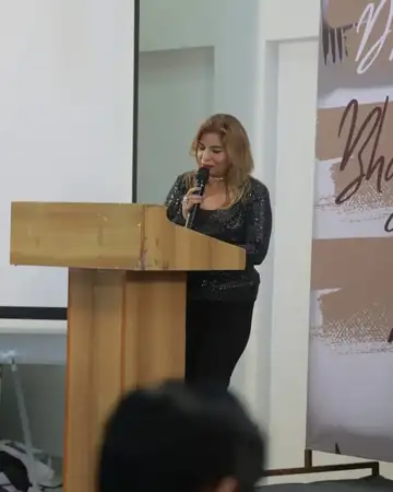 Anu Manocha at the podium hosting a speaker session
