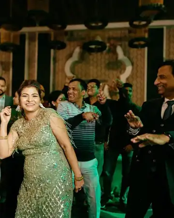 Anu Manocha dancing with guests on the dance floor at a wedding party