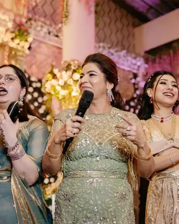 Anu Manocha singing with family members at a wedding sangeet