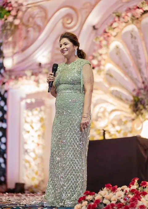 Anu Manocha in a green sequinned gown anchoring a wedding function