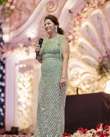 Anu Manocha in a green sequinned gown anchoring a wedding function