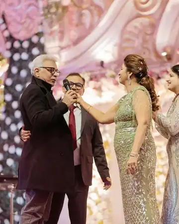 Family members sharing a moment on stage while Anu Manocha hosts