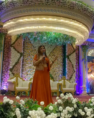 Anu Manocha on a wedding stage decorated with white flowers
